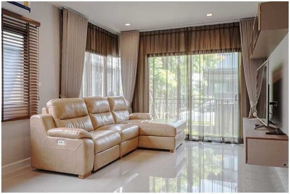 Phong-khach-duoc-thiet-ke-hien-dai-voi-tong-chu-dao-mau-vang-be-sofa-da-cao-cap-ket-hop-cung-mau-rem-cua-tao-nen-khong-gian-hai-hoa-ve-mau-sac